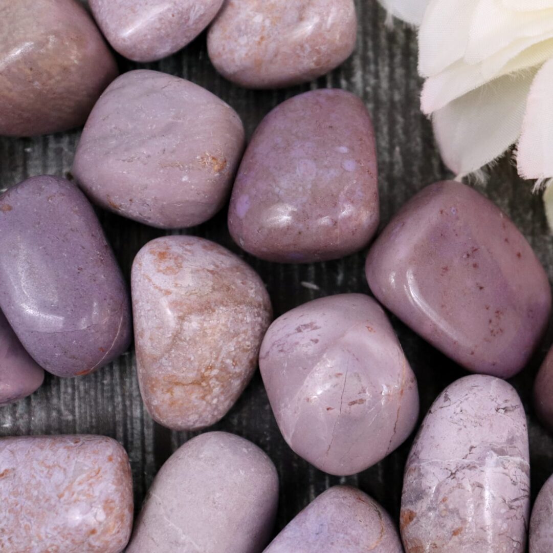 A bunch of purple stones on a wooden table.