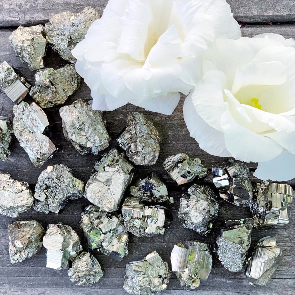 A pile of rocks and flowers on a wooden table.