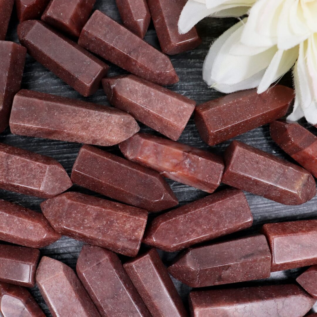 A bunch of red stones with a flower in the middle.