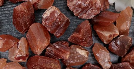 A pile of red quartz crystals on a table.