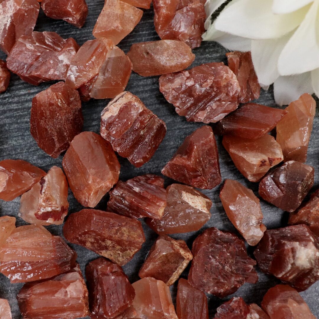 A pile of red quartz crystals on a table.