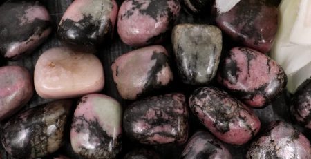 A pile of pink and black stones with a flower.