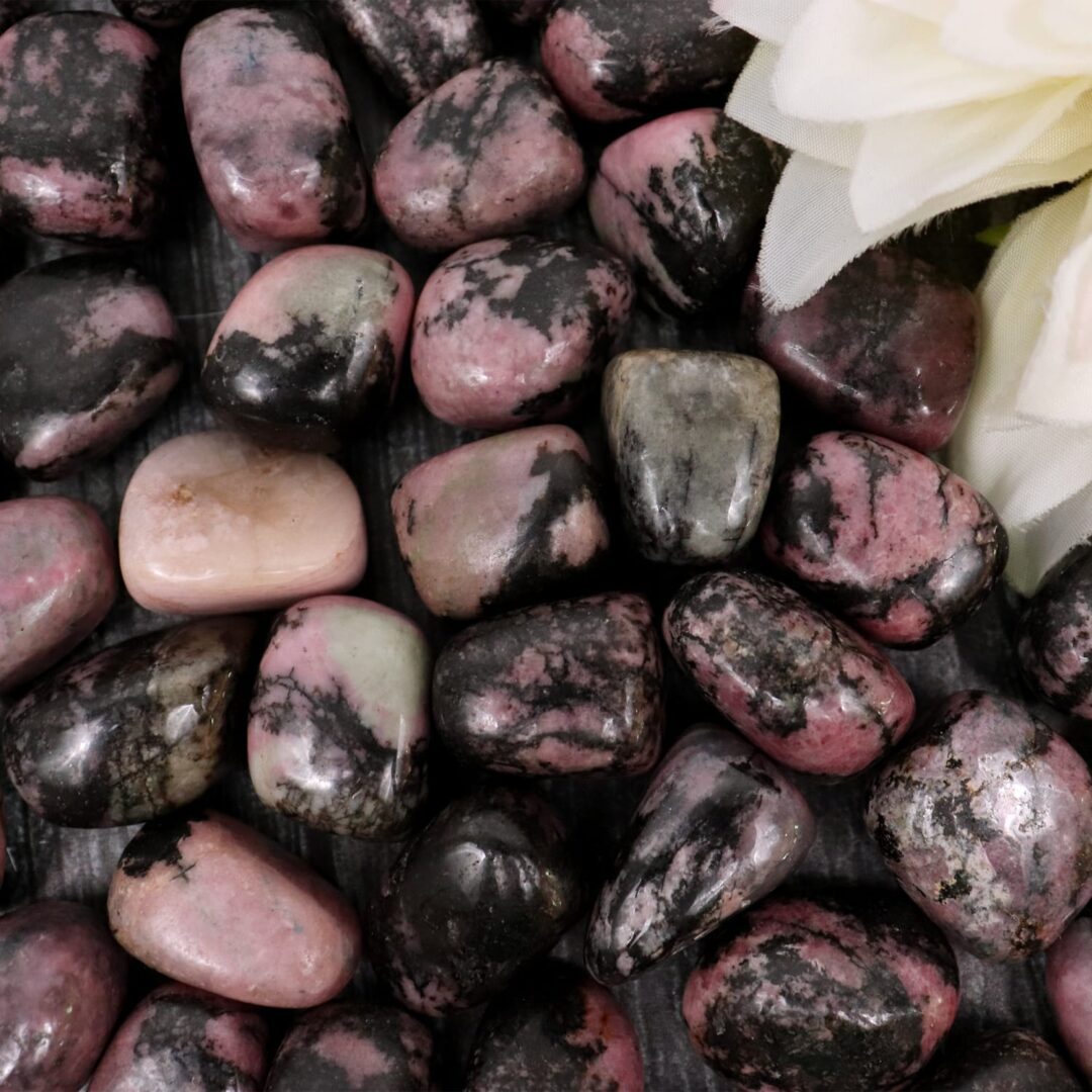 A pile of pink and black stones with a flower.