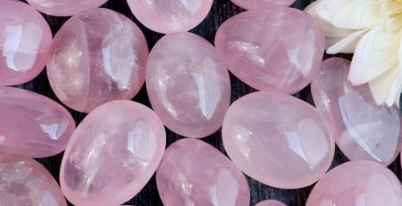 A pile of pink quartz stones with a flower in the middle.