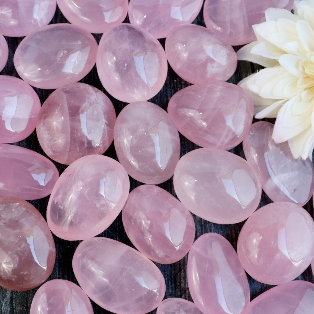 A pile of pink quartz stones with a flower in the middle.