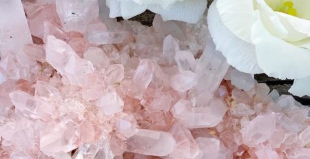 A bunch of rose quartz crystals and white flowers.