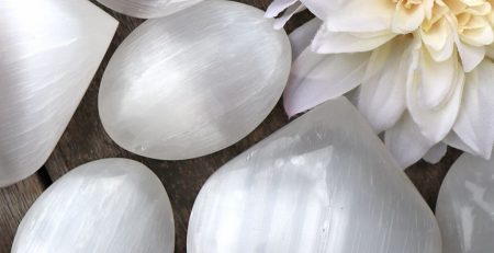 A bunch of white heart shaped quartz crystals on a wooden table.