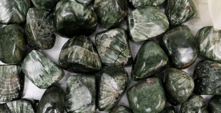 A bunch of green jasper stones on a white table.