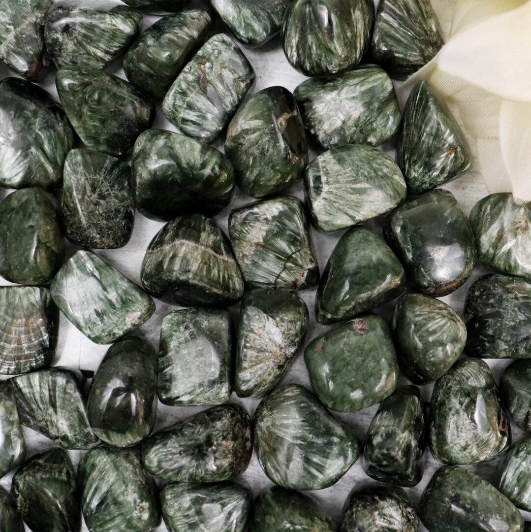 A bunch of green jasper stones on a white table.