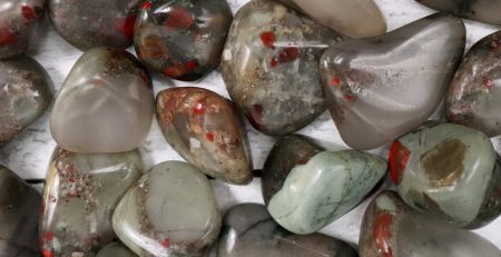 A pile of gray and red stones on a white surface.