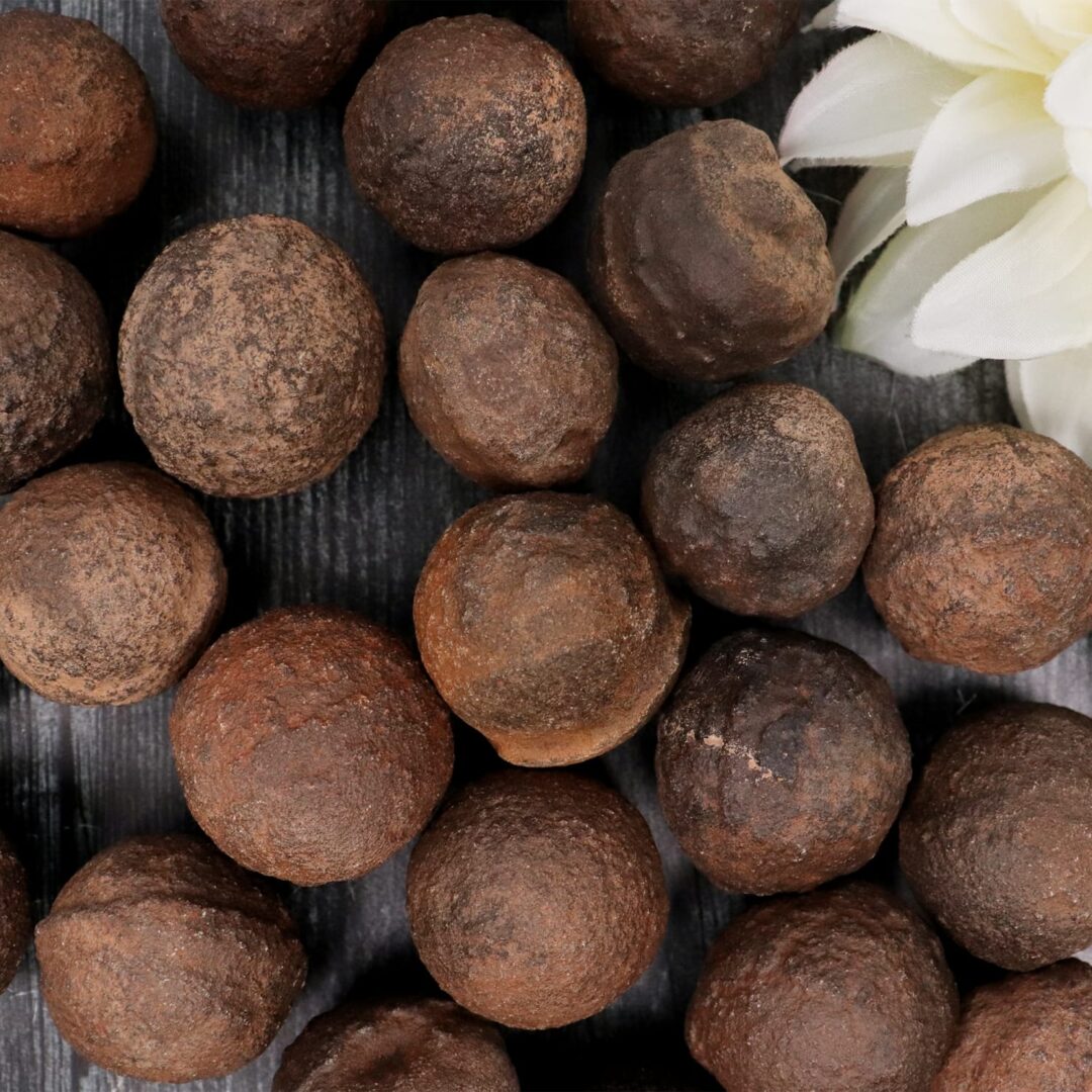 A bunch of brown nuts with a flower in the middle.