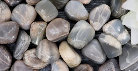 A pile of gray and white pebbles on a wooden table.