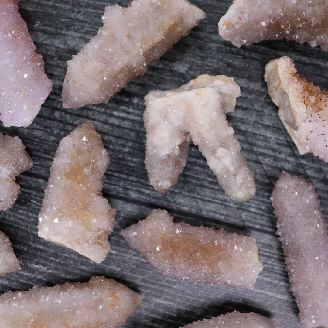 A bunch of pink crystals on a wooden surface.