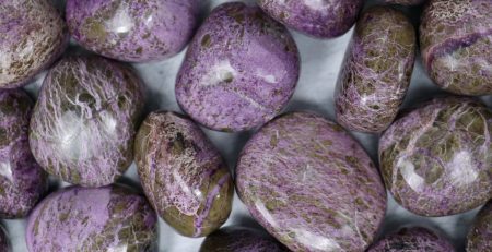 A pile of purple stones on a white surface.