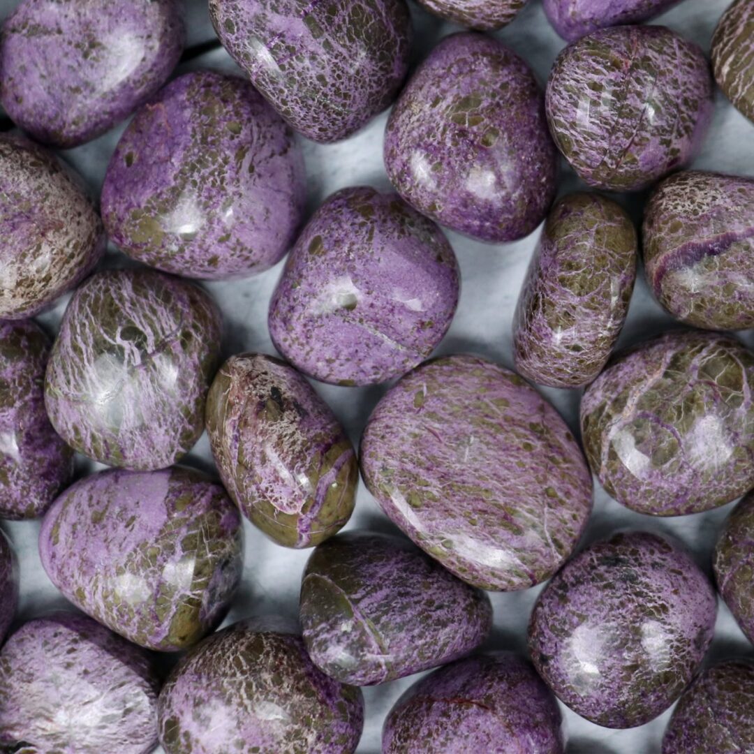 A pile of purple stones on a white surface.