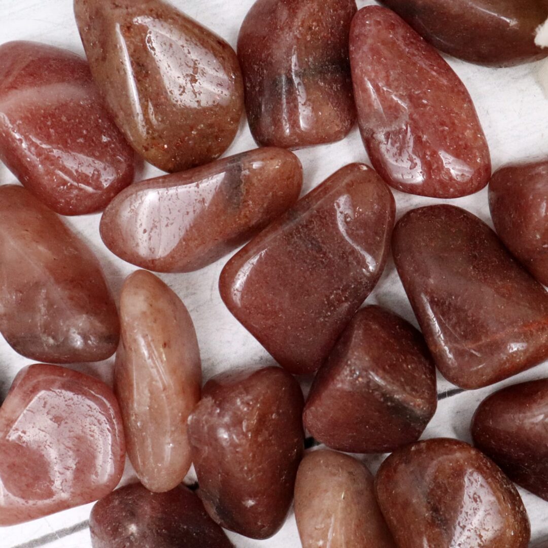 A pile of red jasper stones on a white surface.