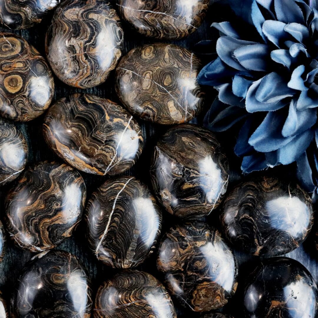 A group of black and blue marble eggs on a wooden table.