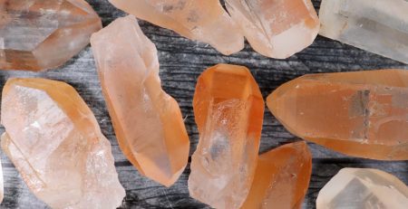 A pile of orange and yellow crystals on a wooden surface.