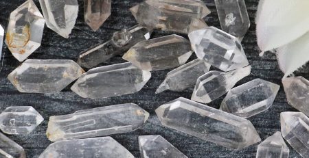 A pile of clear quartz crystals on a table.