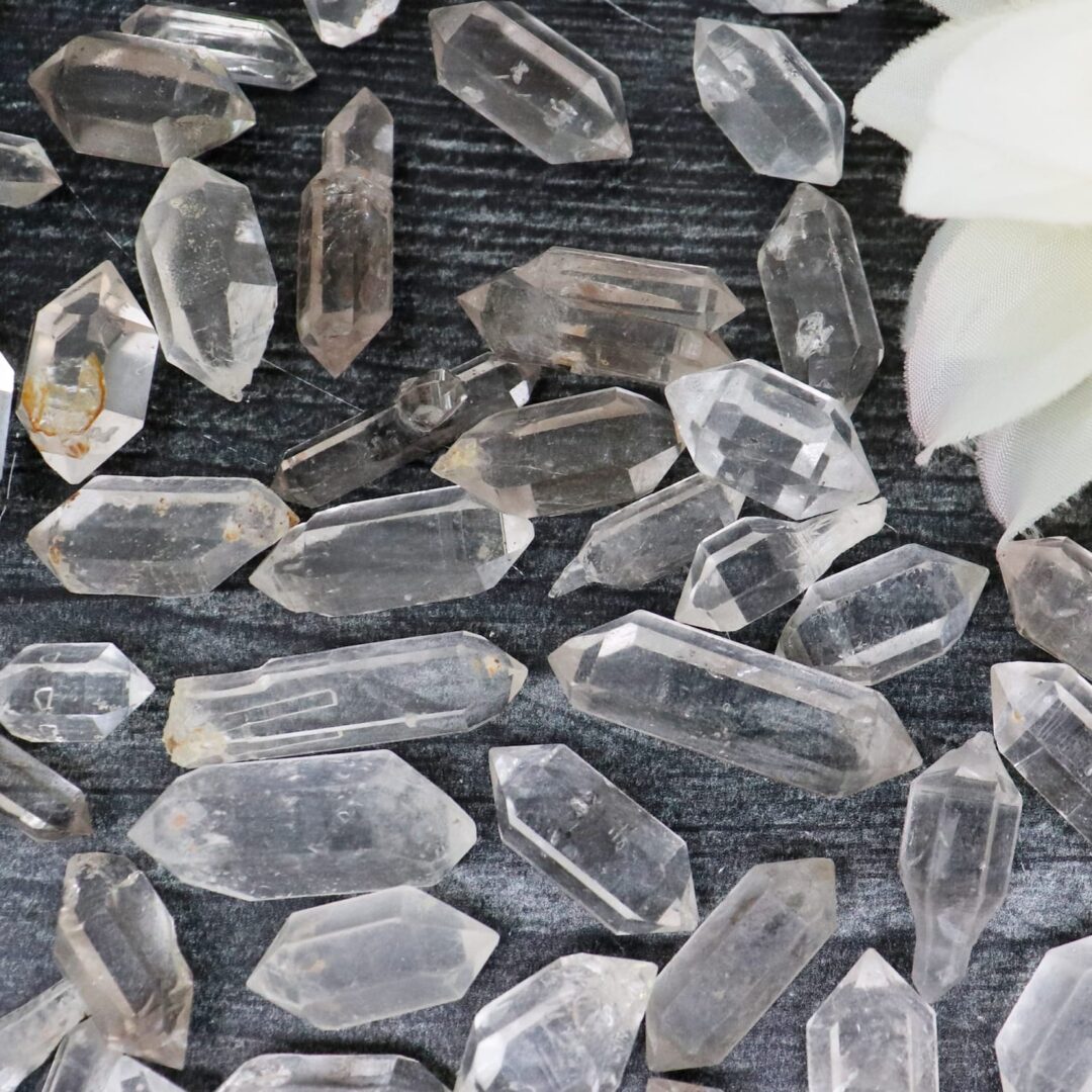 A pile of clear quartz crystals on a table.