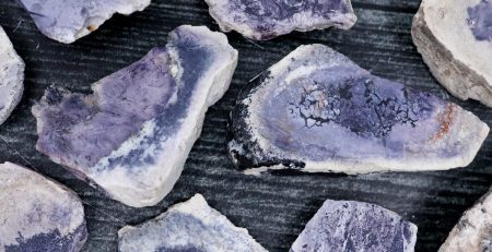 Purple amethyst pieces on a wooden surface.