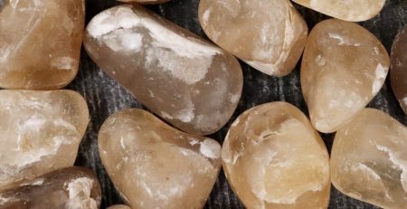 A pile of brown and white stones on a wooden surface.