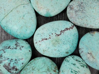 A group of turquoise stones on a wooden table.