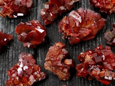 Red garnet crystals on a black surface.