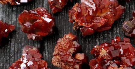 Red garnet crystals on a black surface.