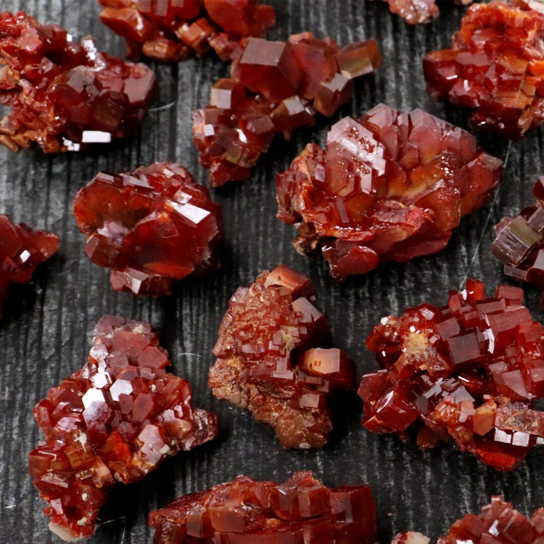 Red garnet crystals on a black surface.