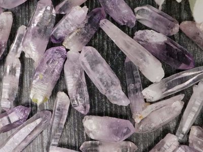 Amethyst crystals in a pile on a table.