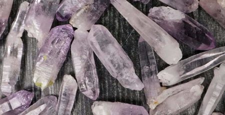 Amethyst crystals in a pile on a table.