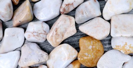 A pile of white and brown pebbles on a wooden surface.