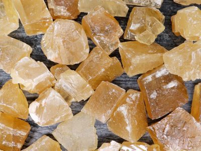 A pile of yellow crystals on a wooden surface.