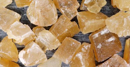 A pile of yellow crystals on a wooden surface.