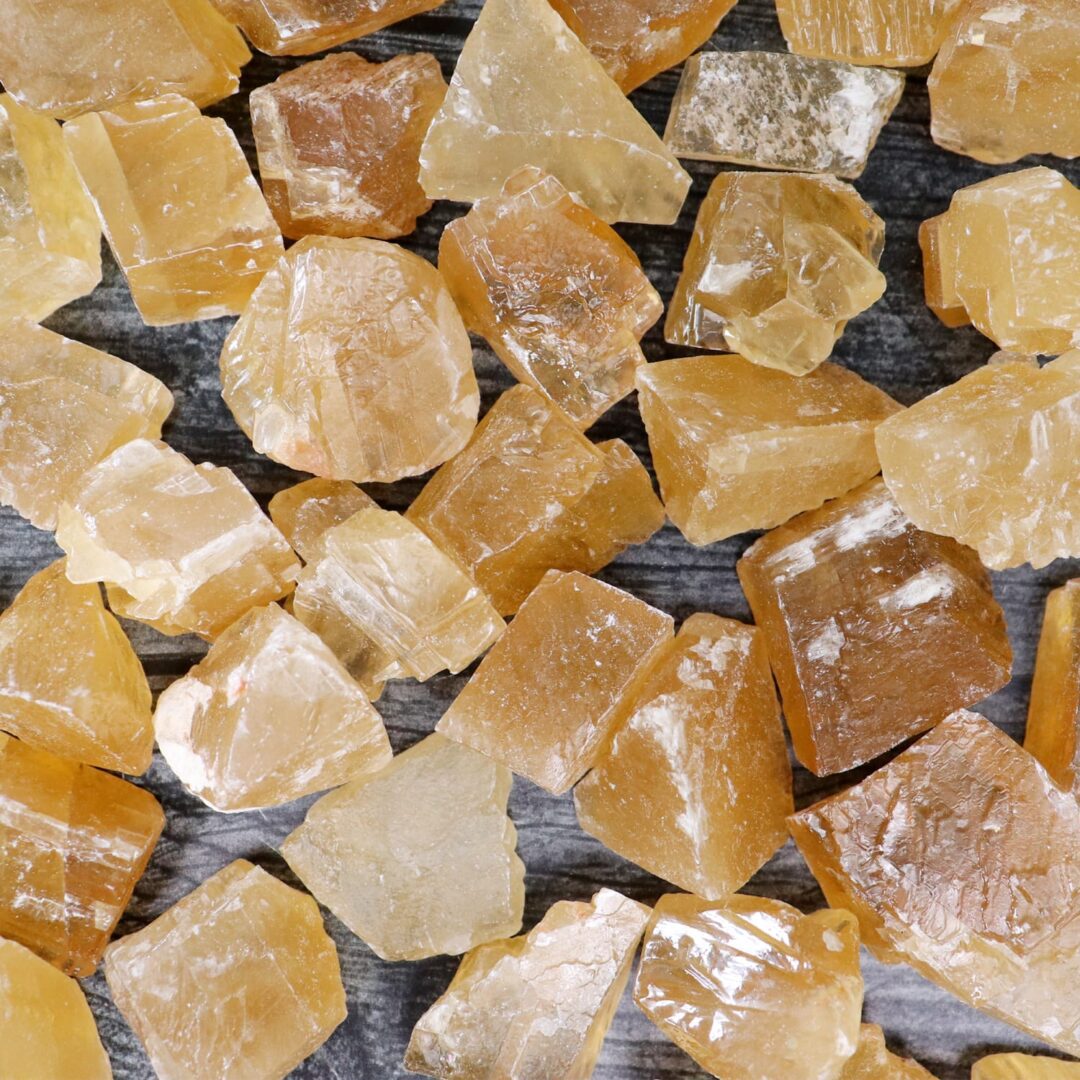 A pile of yellow crystals on a wooden surface.