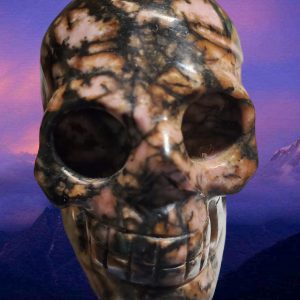 A 2 Pink and Black Rhodonite Crystal Skull With Mountains