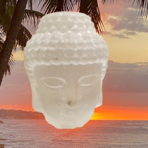 White Buddha statue against sunset.