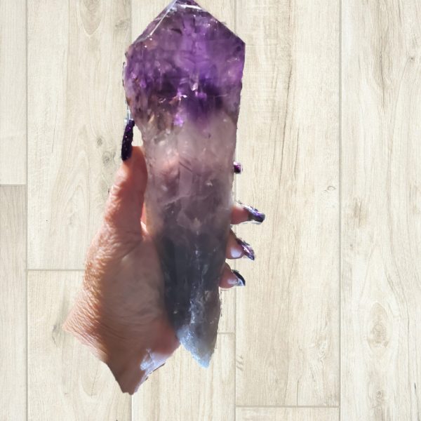Hand holding a large amethyst crystal.