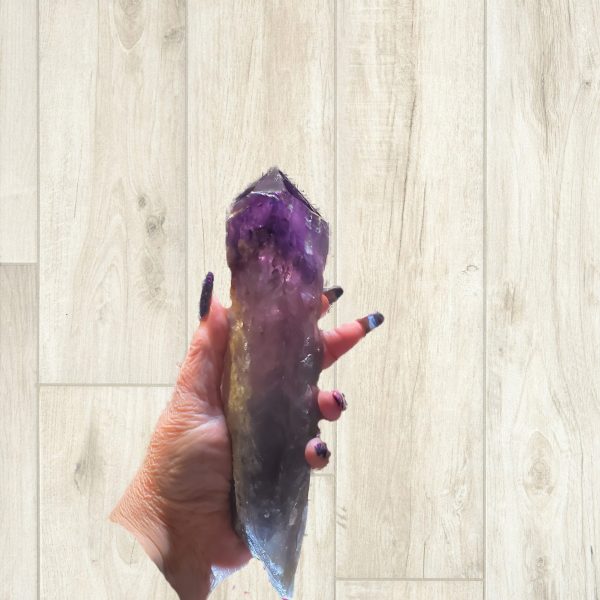 Large purple amethyst crystal in hand.