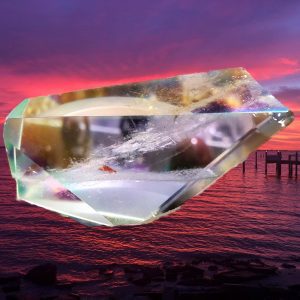 Crystal prism refracting sunset over water.