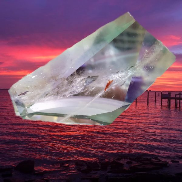 Clear crystal prism at sunset over water.