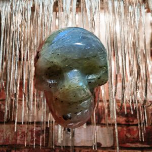 Green gemstone skull sculpture hanging.