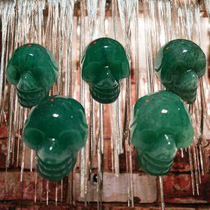 Five green jade skull pendants hanging.