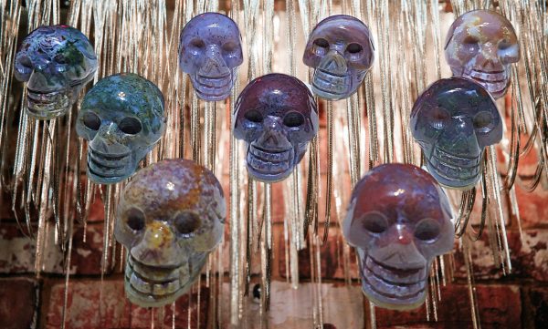 Blue and purple skull pendants hanging from chains.