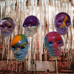 Five colorful skull ornaments hanging from chains.