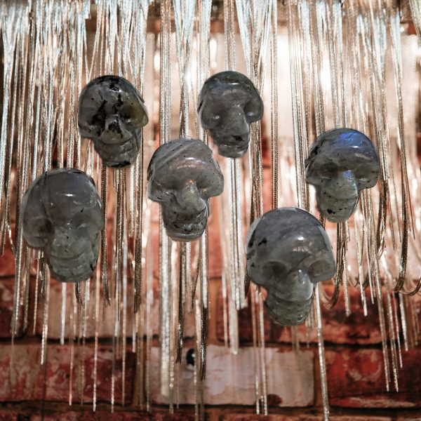 Six crystal skull pendants on chains.