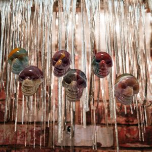 Colorful skull pendants hanging on chains.