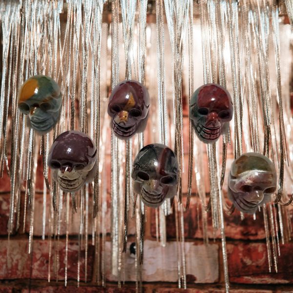 Six colorful skull pendants hanging on chains.