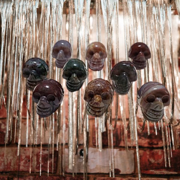 Stone skull pendants hanging on chains.